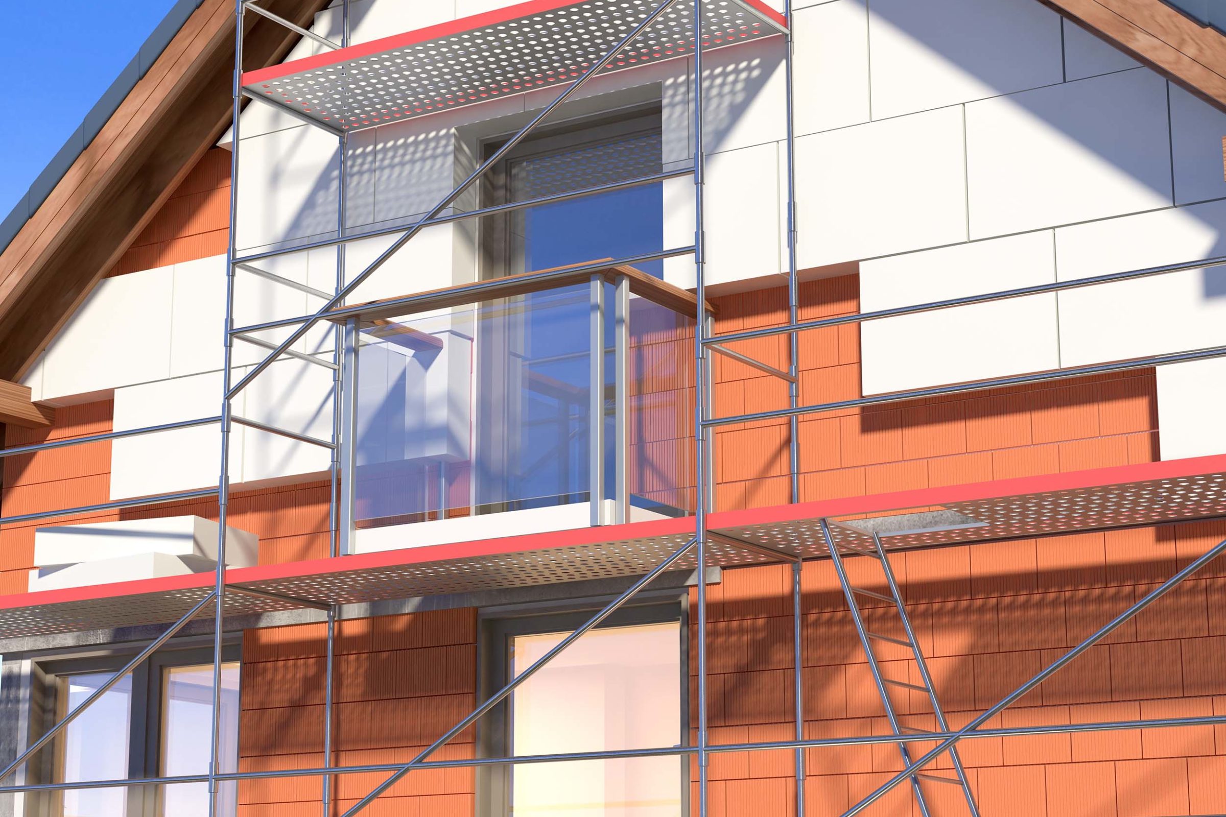 Nahaufnahme eines Hauses im Bau. Der Rohbau ist rot und wird weiss verkleidet. Vor dem Haus ist ein Geruest aufgebaut. Innerhalb des Geruests wird ein Glasbalkon angebaut.